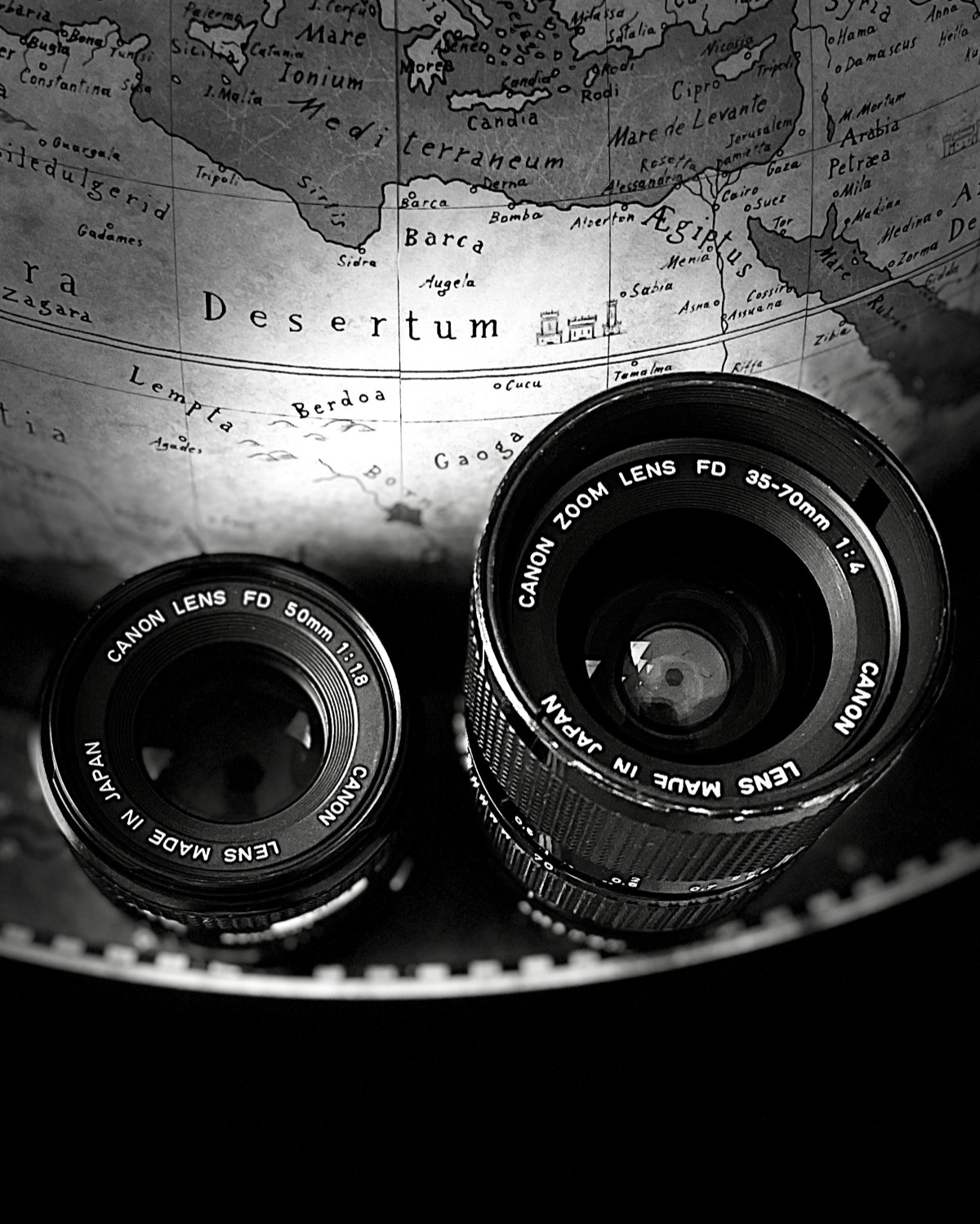 Two Canon FD lenses on a map